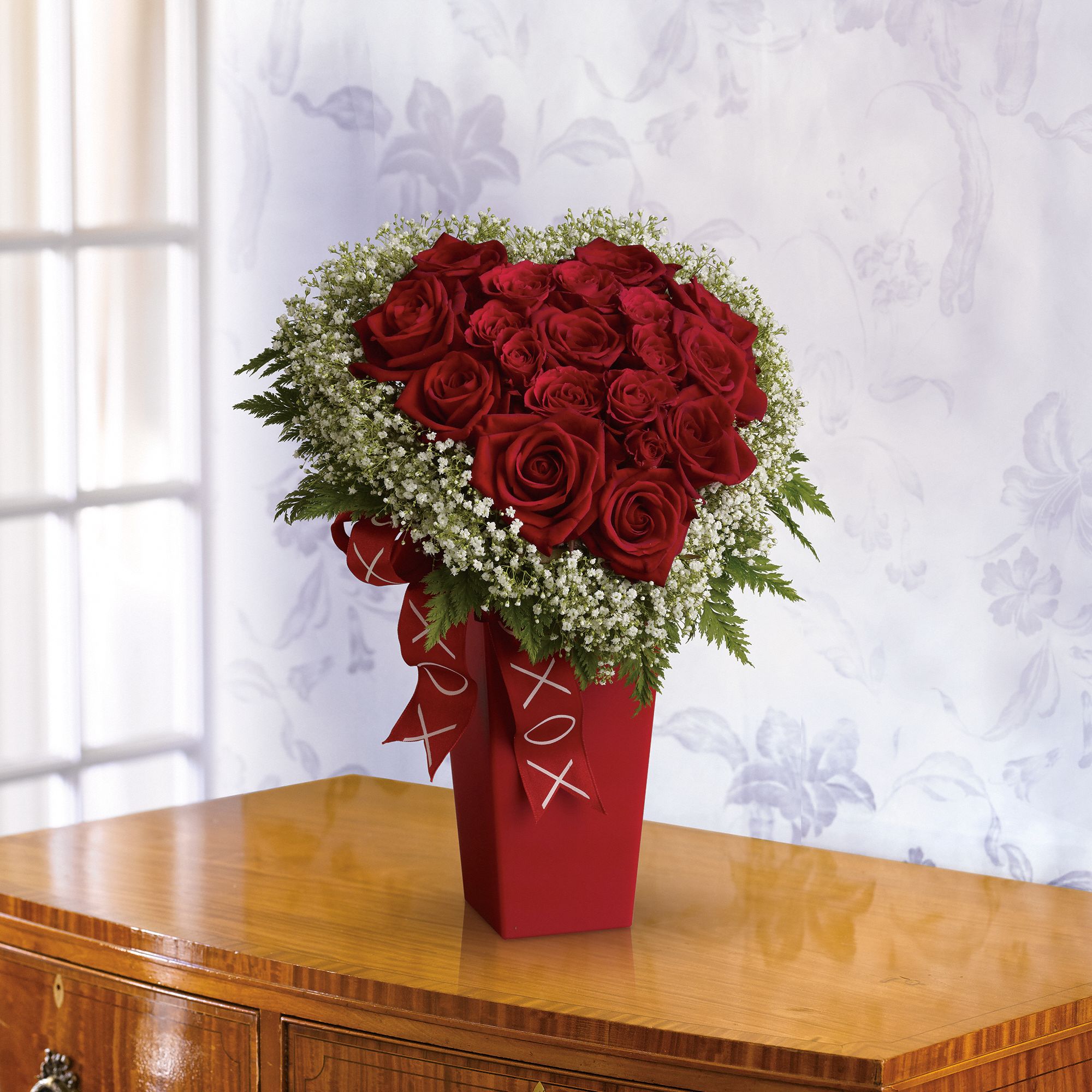 Heart & Soul bouquet - Red roses and white Million Star gypsophila accented with fern are delivered in a red vase decorated with a satin ribbon.
